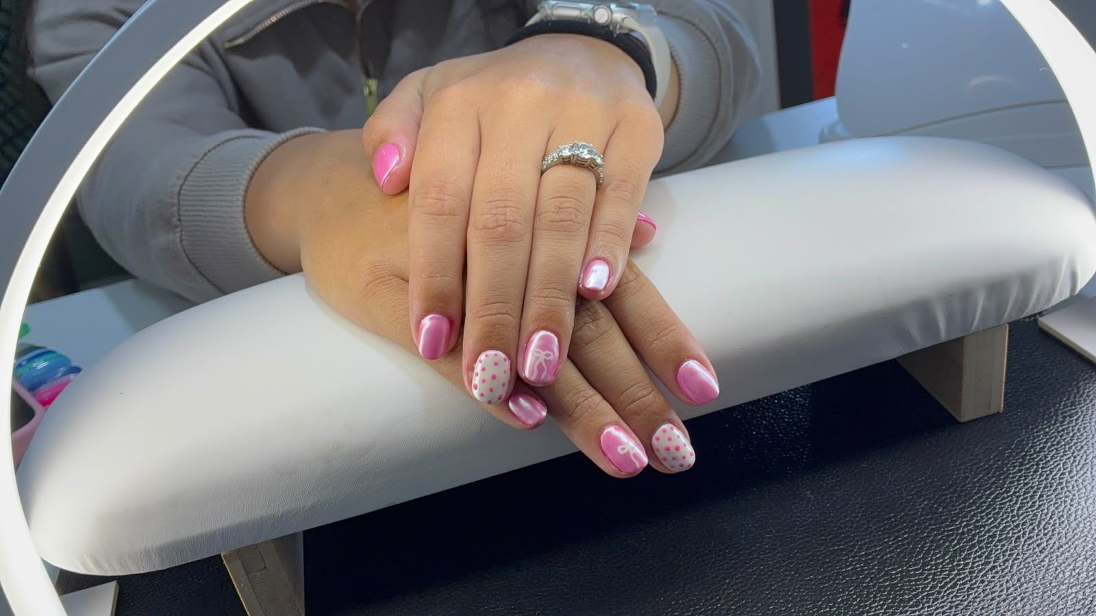 Pink nails with bows and dotted nail art, work by Emmi's Nail Bar