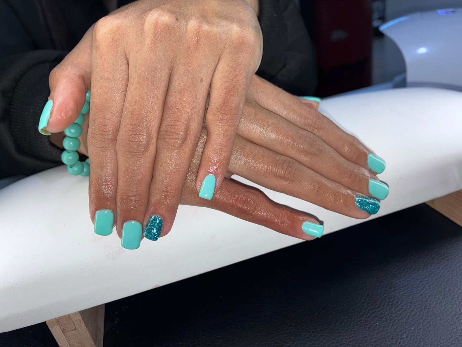 Teal nails with glitter accent